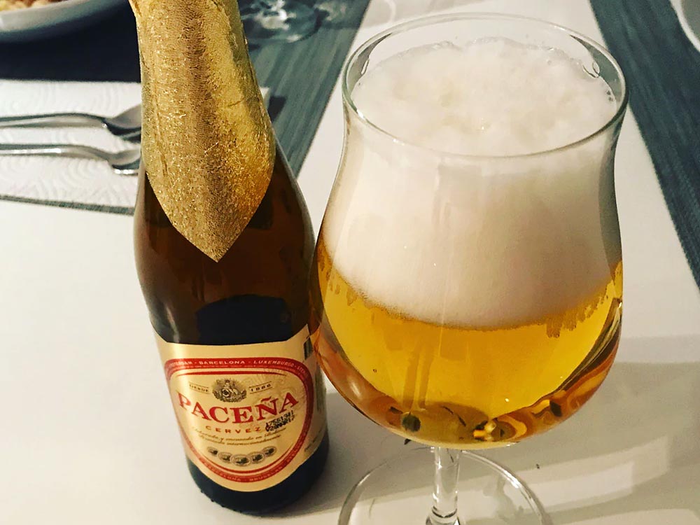 Eine Flasche Cerveza Paceña zusammen mit einem mit Bier gefülltem Glas